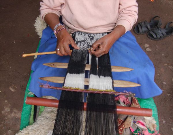Peruaanse wevers weeft sjaal van alpaca wol
